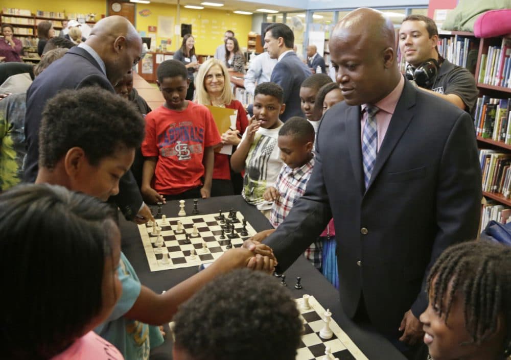 Chess Grand Master Maurice Ashley, right, shakes the hand of his opponent, a student from Walnut Grove Elementary School, after defeating him in a friendly match at a news conference to announce an initiative by Ascension and the St. Louis Chess club to start chess clubs in the schools of the Ferguson-Florissant school district, Tuesday, Sept. 15, 2015 at Walnut Grove Elementary School in Ferguson, Missouri. (Tom Gannam/Invision for The Chess Club and Scholastic Center of St. Louis via AP)