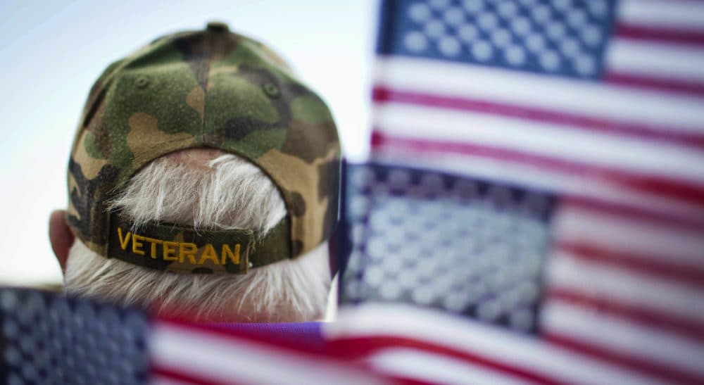 Frank Lindsey, wears a Veterans hat surrounded by flags as he attends a Veterans Day parade Tuesday, Nov. 11, 2014, in Montgomery, Ala.(Brynn Anderson/ AP)