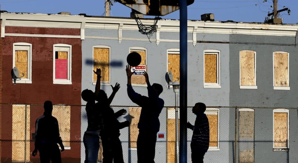 Countless Americans are living on virtually no income. The shocking fact of these families and the complex strategies they use to survive is a national disgrace, says Renée Loth. In this photo, children play basketball at a park near blighted row houses in Baltimore, Monday, April 1, 2013. (Patrick Semansky/ AP)