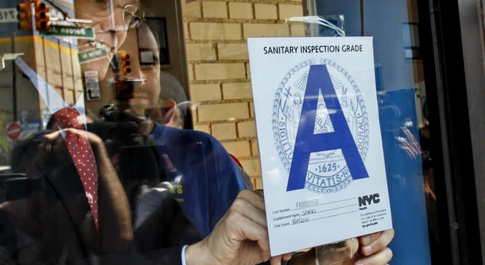 In this July 28, 2010 file photo, New York City Health Commissioner Thomas Farley post the health department's first &quot;A&quot; grade award for sanitary conditions on the window of Spark's Deli in Long Island City, N.Y. (Bebeto Matthews/ AP)