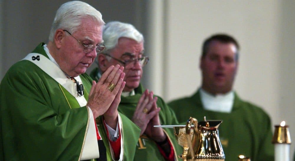 Cardinal Bernard Law, left, celebrates mass at the Cathedral of the Holy Cross in Boston Sunday, July 21, 2002. Law resigned in disgrace as archbishop of Boston over his role in the clergy sex abuse crisis. (John Bohn/ AP)
