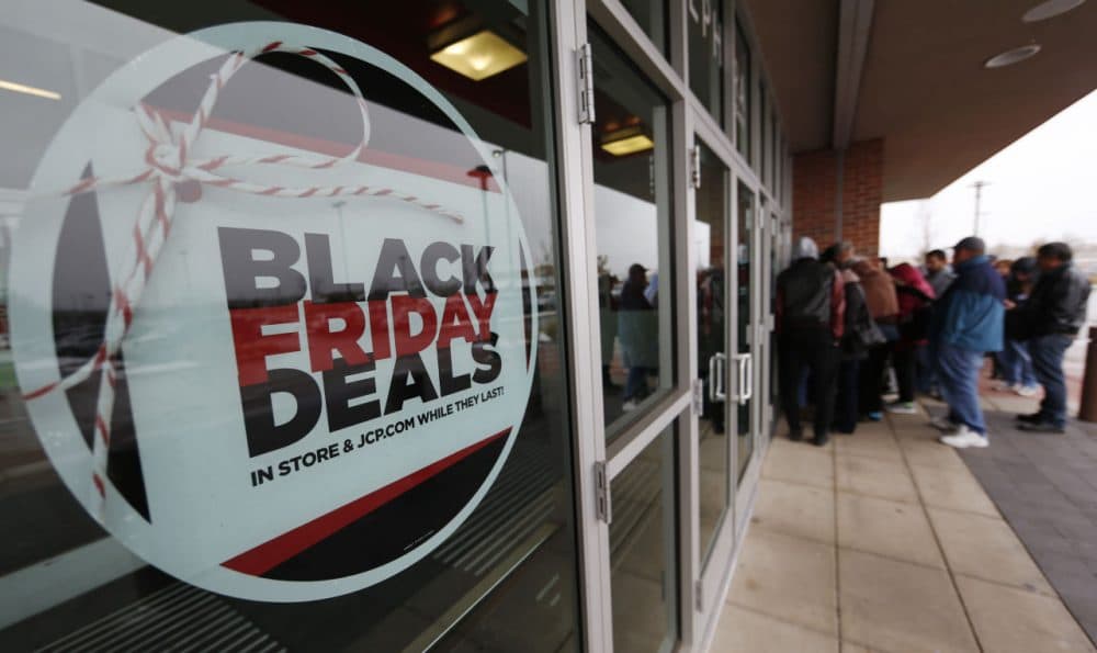 A sign promoting Black Friday specials is displayed in the window of a J.C. Penny store as shoppers queue up at the door for a 3 p.m. opening, Thursday, Nov. 26, 2015, in northeast Denver. The store opened two hours before other retailers to cash in on a flurry of bargain hunters, some who said that they waited for three hours to be one of the first people queued up outside. (David Zalubowski/AP Photo)