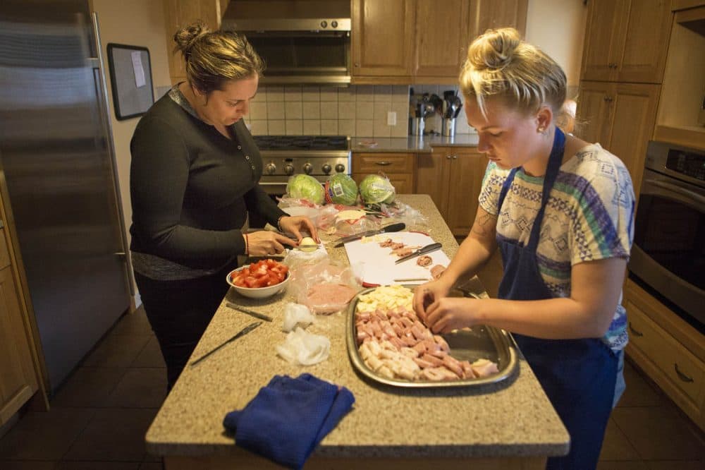Michelle Aguilar, left, and Allison Lees prepare lunch for the other residents at the Project COPE Women’s Residential Program, an inpatient substance use treatment program for women. (Jesse Costa/WBUR)