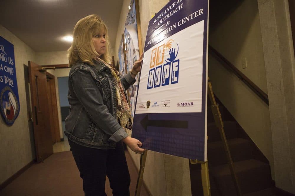 Susan Silva sets up an East Bridgewater H.O.P.E. sign at the Community Covenant Church where the non-profit hosts Substance Abuse Outreach and Intervention Center nights. (Jesse Costa/WBUR)