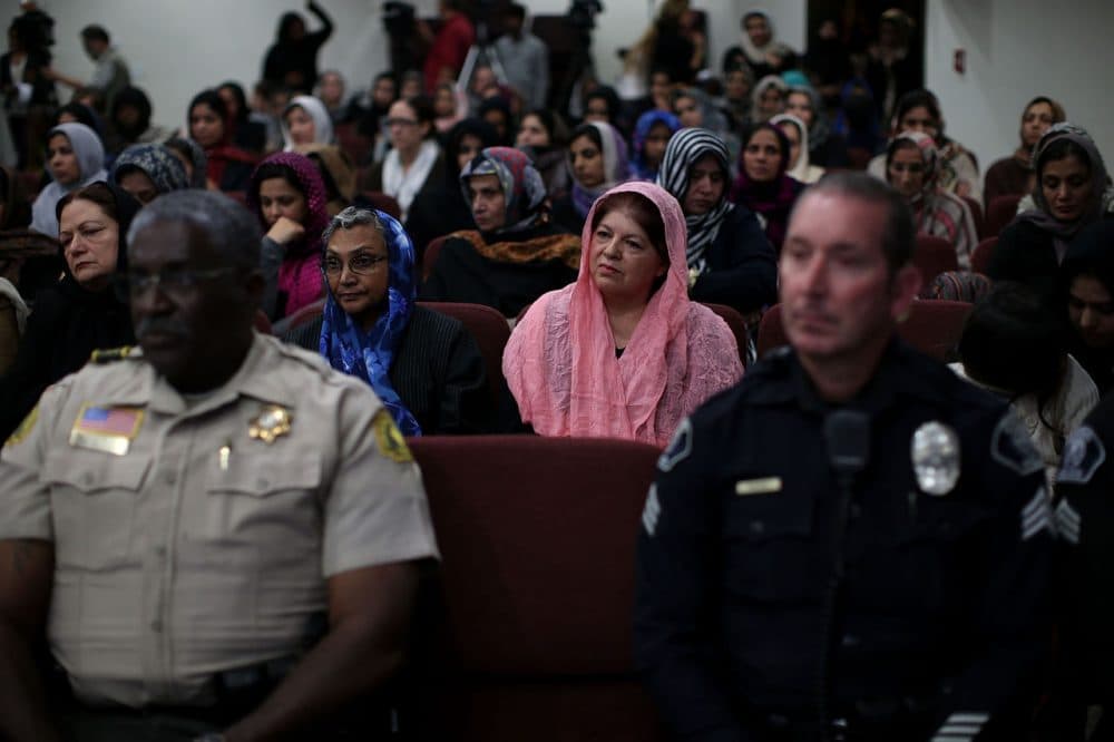 Muslim women sit behind police officers during a prayer vigil at Baitul Hameed Mosque on December 3, 2015 in Chino, California, a day after the mass shooting at the Inland Regional Center in San Bernardino that left at least 14 people dead.  (Justin Sullivan/Getty Images)