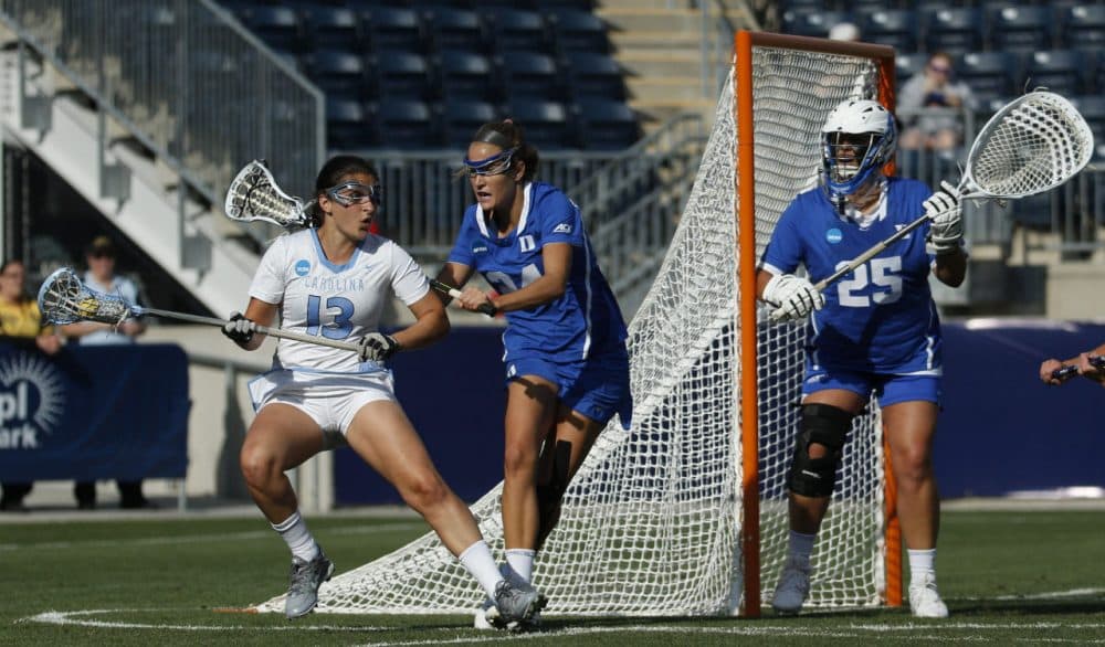 North Carolina's attack/midfield Sammy Jo Tracy, left, tries to get past Duke's midfielder Katie Trees, center, as goalie Kelsey Duryea, right, looks on during the first half of the semifinals in the NCAA Division I women's lacrosse tournament, Friday, May 22, 2015, in Chester. (AP Photo/Chris Szagola)