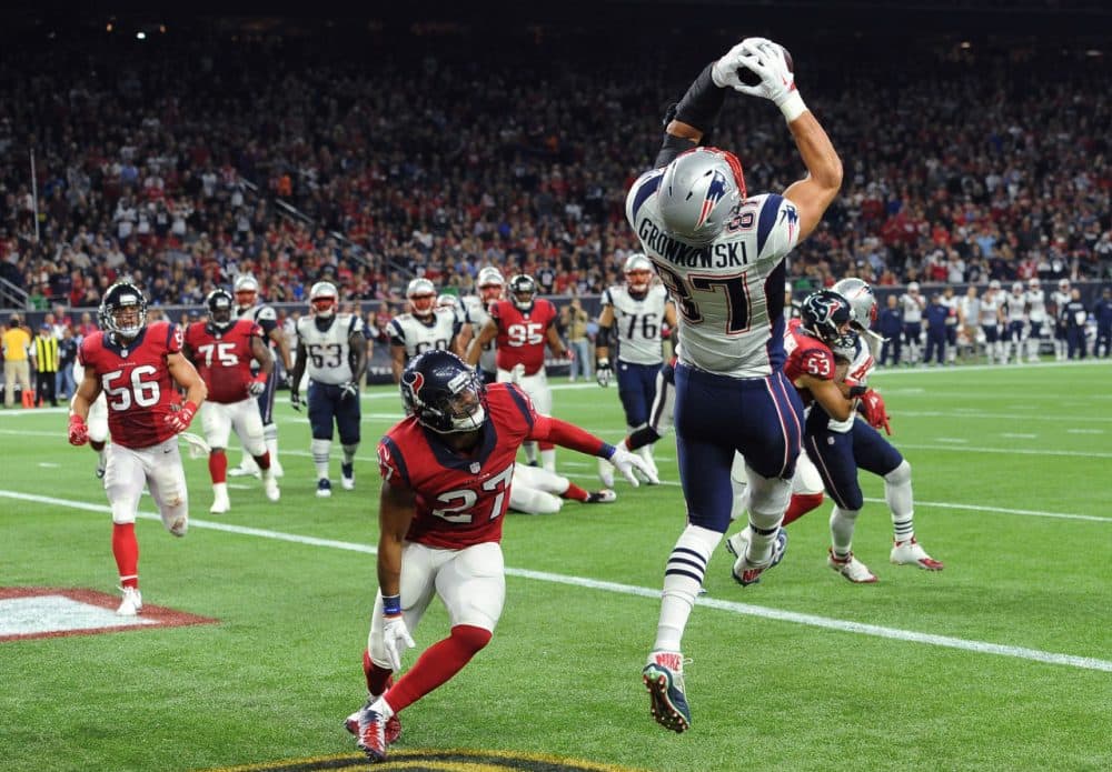 New England Patriots tight end Rob Gronkowski (87) catches a pass for a touchdown over Houston Texans strong safety Quintin Demps (27) during the game last night. Patriots won 27-6 to clinch a spot in the playoffs. (George Bridges/AP)