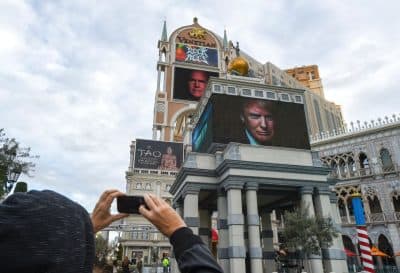 A tourist takes a picture of advertisements for the fifth of the season GOP presidential debate, which will be hosted by CNN on Tuesday, Dec. 15 in Las Vegas. (Robyn Beck//AFP/Getty Images)
