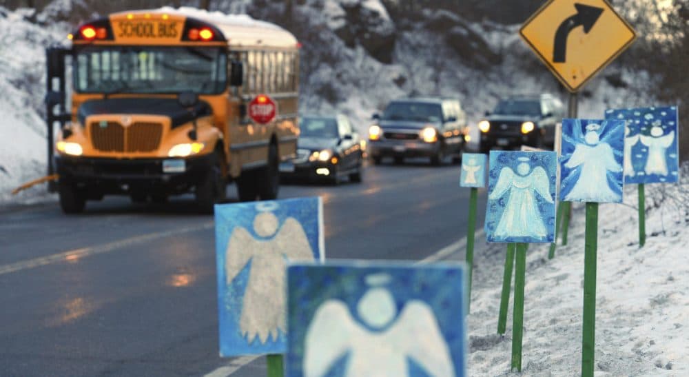 In this Jan. 3, 2013 photo, a bus traveling from Newtown, Conn. stops near 26 angel signs posted along the roadside in Monroe, Conn., on the first day of classes for Sandy Hook Elementary School students since the Dec. 14, 2012, shooting. The massacre in Newtown, in which a mentally troubled young man killed 26 children and teachers, served as a rallying cry for gun-control advocates across the nation. But in the three years since, many states have moved in the opposite direction, embracing the National Rifle Association’s axiom that more “good guys with guns” are needed to deter mass shootings. (Jessica Hill/AP)
