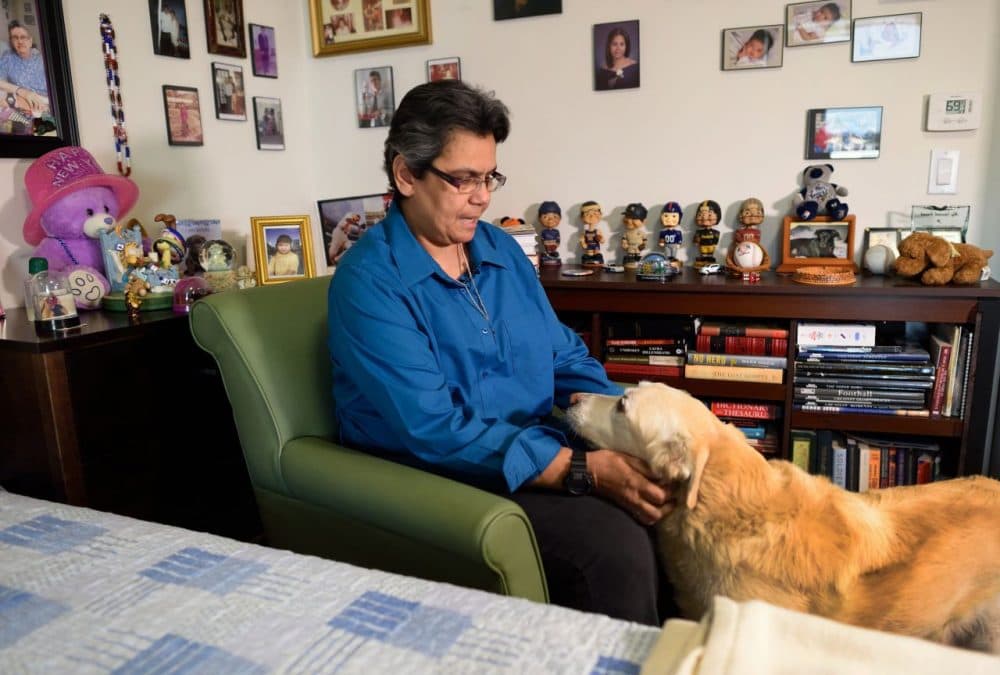 Disabled veteran Gloria Montes pets her dog Cache in her Bronx apartment November 9, 2015 in New York. Montes, who was forced to sleep in a car or on friends' floors until she found a place at a housing unit in the Bronx in September 2014, says she wants the military to do more to help veterans adjust to civilian life, and navigate the benefits that are open to them. (Don Emmert/AFP/Getty Images)