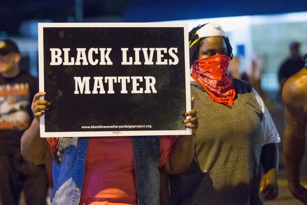 Demonstrators, marking the one-year anniversary of the shooting of Michael Brown, protest along West Florrisant Street on August 10, 2015 in Ferguson, Missouri. Brown was shot and killed by a Ferguson police officer on August 9, 2014. His death sparked months of sometimes violent protests in Ferguson and drew nationwide focus on police treatment of black suspects.  (Scott Olson/Getty Images)