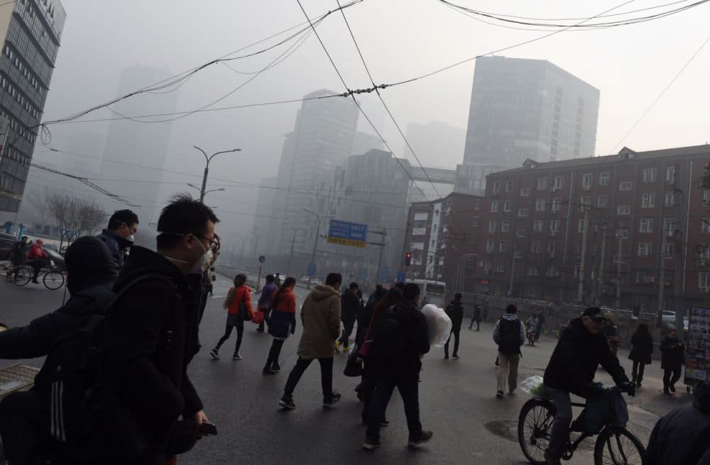 People cross a road on a polluted day in Beijing on December 14. Authorities issued the second red alert for smog this month today. (Greg Baker/AFP/Getty Images)