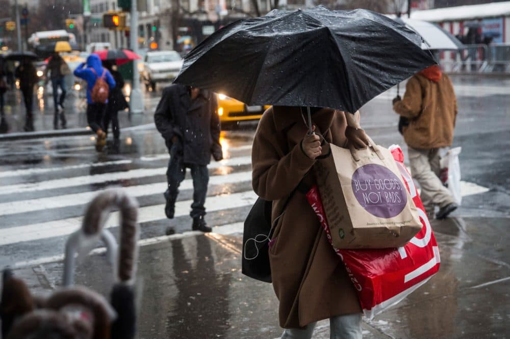 People walk along the sidewalk in the rain on Christmas Eve on December 24, 2014 in New York City. (Andrew Burton/Getty Images)