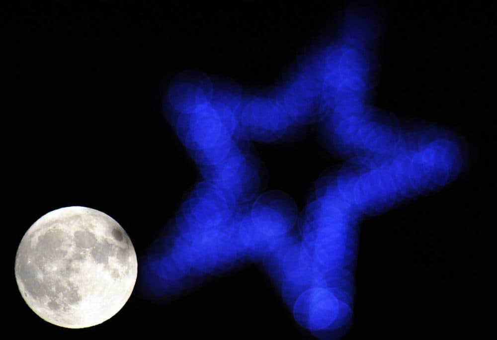 The moon is seen beyond an illuminated star on top of a Christmas tree in Hartley Wintney, 40 miles west of London on December 27, 2012. (Adrian Dennis/AFP/Getty Images)
