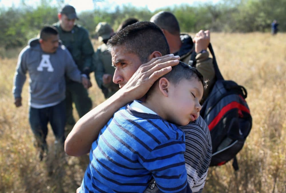 A father holds his sleeping son, 3, after they and other undocumented immigrants were detained by Border Patrol agents on December 7, 2015 near Rio Grande City, Texas. (John Moore/Getty Images)