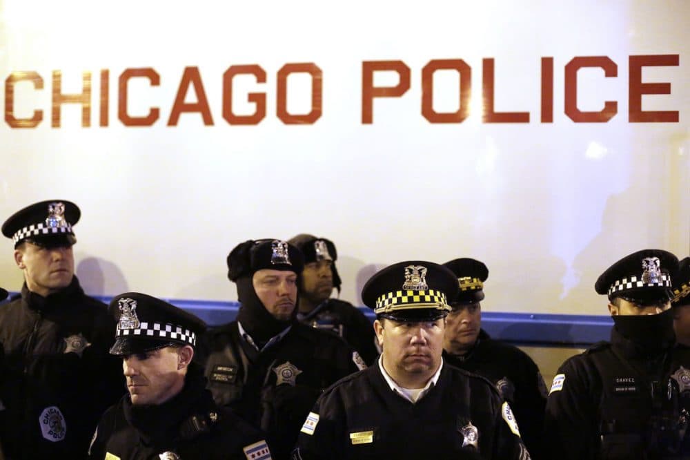 Chicago police officers surround a police vehicle as they watch demonstrators protesting the fatal police shooting of Laquan McDonald December 18 in Chicago, Illinois. (Joshua Lott/Getty Images)