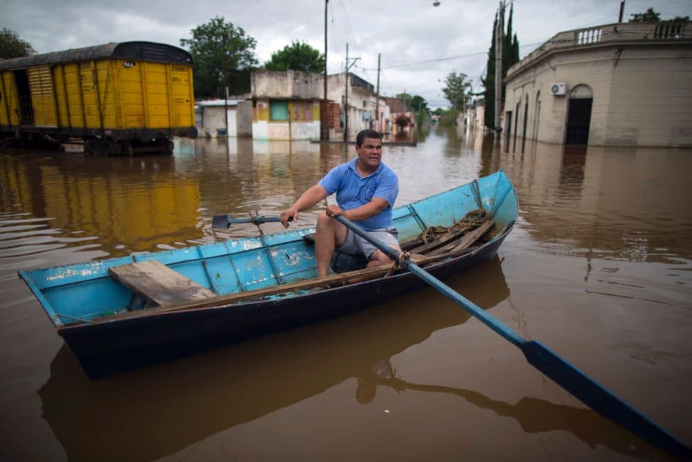 A local rows his boat through a flooded street in Concordia, Entre Rios province, Argentina, on December 29. Over recent days the storms blamed on the &quot;El Niño&quot; weather phenomenon have killed four people in Brazil and two in Argentina. (STR/AFP/Getty Images)