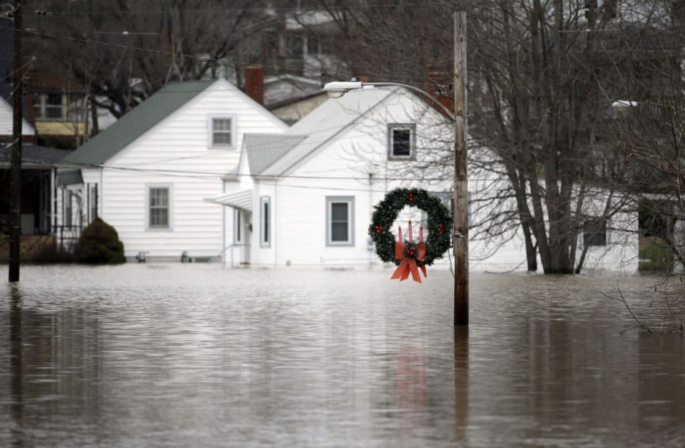 A holiday wreath hangs from a light post surrounded by floodwater from the Bourbeuse River, Tuesday, Dec. 29 in Union, Mo. Flooding across Missouri has forced the closure of hundreds of roads and threatened homes. (Jeff Roberson/AP)