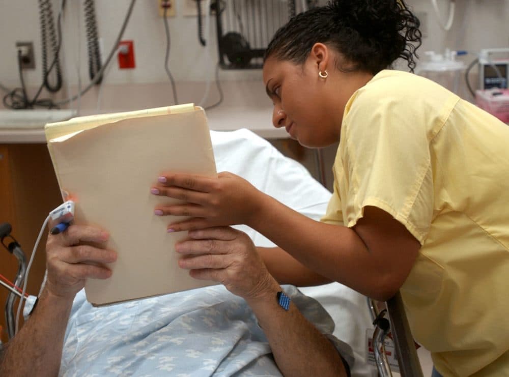 Hospitals take different approaches to support people with low English-speaking ability. In this 2004 photo, medical interpreter Carmen Diaz interprets for Spanish-speaking patient at Temple University Hospital in Philadelphia. (Bradley C. Bower/AP)