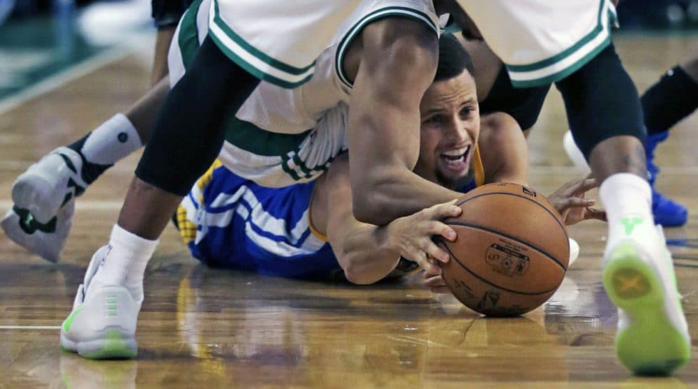 Warriors guard Stephen Curry tries to keep control of the ball as he is surrounded by Celtics during Friday's game in Boston. (Charles Krupa/AP)