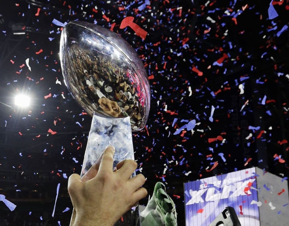 New England Patriots players celebrate with the Vince Lombardi Trophy after the NFL Super Bowl XLIX football game against the Seattle Seahawks Sunday, Feb. 1, 2015, in Glendale, Ariz. The Patriots won 28-24. (AP Photo/David J. Phillip)
