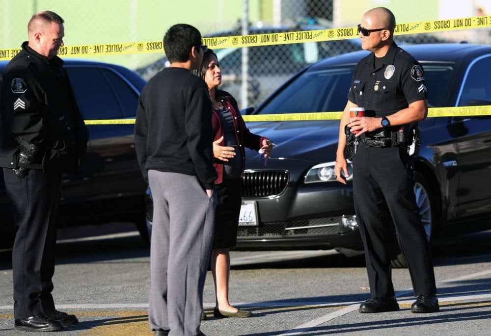 Police officers explain to a parent and her son that his school was closed for the day at Edward Roybal High School in Los Angeles, on Tuesday morning, Dec. 15, 2015. (Richard Vogel/AP)