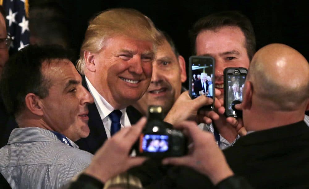 Republican presidential candidate Donald Trump smiles as he has his photograph taken with supporters after being endorsed at a regional police union meeting in Portsmouth, New Hampshire on Thursday. (Charles Krupa/AP)
