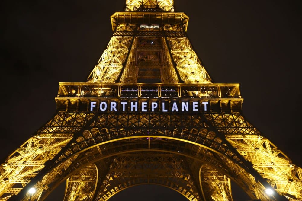 The Eiffel Tower on Friday. The next day, an agreement was finally made by nations participating in the 2015 Climate Conference. (AP Photo/Francois Mori)