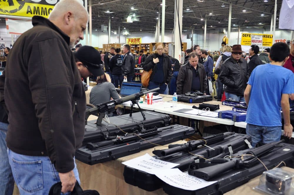 Gun show goers look at various assault-style weapons December 30, 2012 at the Nation's Gun Show in Chantilly, Virginia. Since the Connecticut school shootings, gun sales, particularly assault-style weapons have gone up sharply.  AFP PHOTO/Guillaume MEYER        (Photo credit should read Guillaume Meyer/AFP/Getty Images)