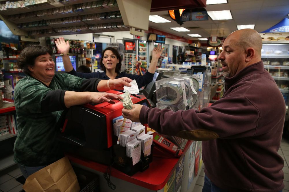Gale Call (left) and Sherrie Haines (center) sell a Powerball ticket to Mike Nastasi (right) at the BP gas station, January 6, 2015 in Dunkirk, Maryland. (Mark Wilson/Getty Images)