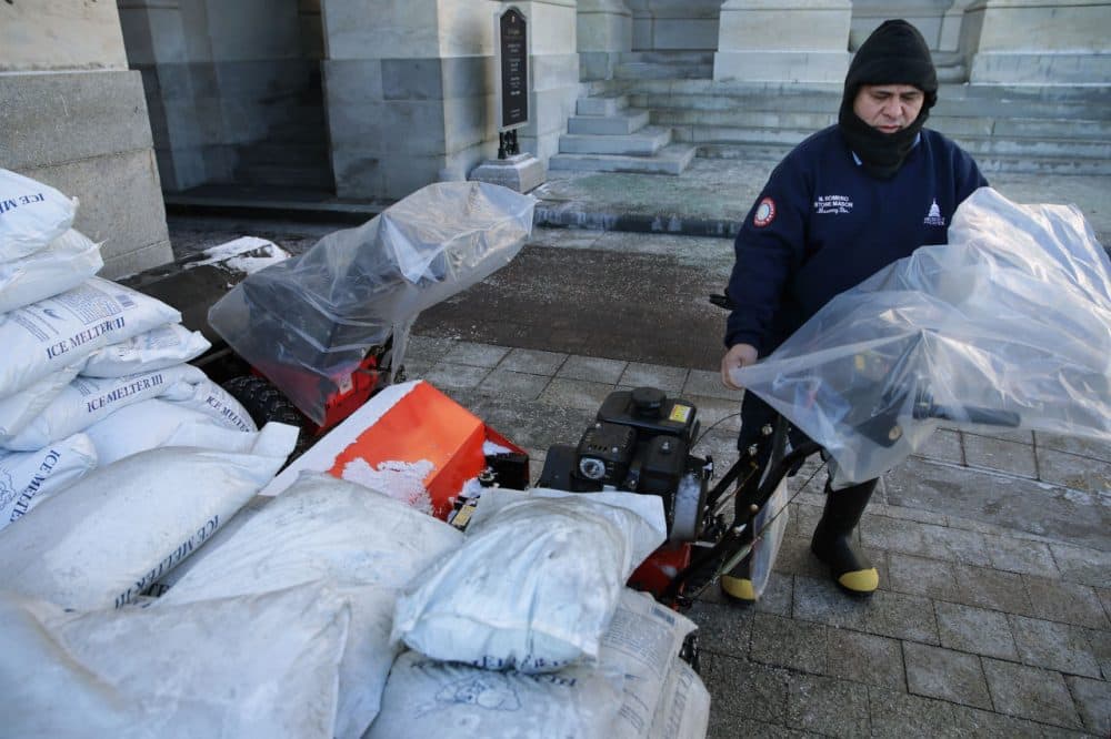 Surrounded by bags of ice-melting salt, stone mason Medaro Romero covers gas powered snow sweepers in plastic bags in preparation for a coming winter storm outside the U.S. Capitol January 21, 2016 in Washington, DC. One inch of snowfall delayed school openings in the greater Washington, DC, area on Thursday as people along the Easter Seaboard prepare for a blizzard to arrive within the next 24 hours. (Chip Somodevilla/Getty Images)