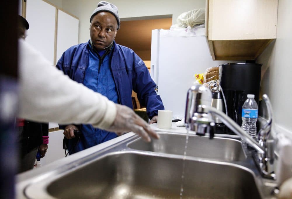 A handyman explains a new water filter to Terrence Tyler at his residence in Shiloh Commons, January 21, 2016 in Flint, Michigan. The city's water supply had been contaminated by lead after a switch from Lake Huron to the Flint river as a source in April, 2014. At a local fire station, residents were provided with water testing jugs, filters and clean water brought in by the National Guard. Residents also brought in water samples from their homes which would be sent out for lead testing. (Sarah Rice/Getty Images)