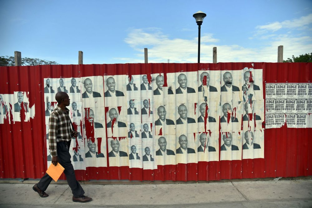 A man walks past election posters of presidential candidate Jovenel Moise of the PHTK political party, in front of the National Palace in Port-au-Prince, on January 21, 2016. 
The second round of presidential elections is scheduled for January 24 between ruling party candidate Jovenel Moise and Jude Celestin. Celestin has said he does not want to participate in the January 24 run-off against Moise, who has yet to submit his official resignation to the Provisional Electoral Council (CEP).  (Hector Retamal/AFP/Getty Images)
