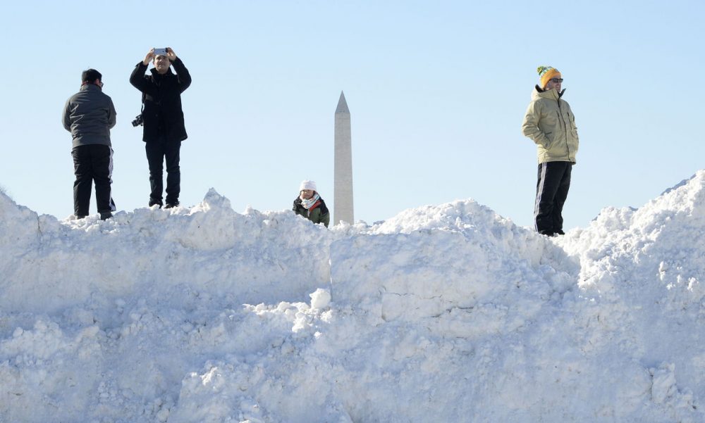 People stand on top of a pile of snow on January 24, 2016 in Washington, D.C.
Millions of people in the eastern United States started digging out Sunday from a huge blizzard that brought New York and Washington to a standstill, but the travel woes were far from over. The storm -- dubbed &quot;Snowzilla&quot; -- killed at least 18 people after it walloped several states over 36 hours on Friday and Saturday, affecting an estimated 85 million residents who were told to stay off the roads and hunker down in doors for their own safety. (Olivier Douliery/AFP/Getty Images)