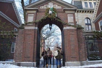 Students walking in and out of one of the gates of Harvard Yard at Harvard University. (Jesse Costa/WBUR)