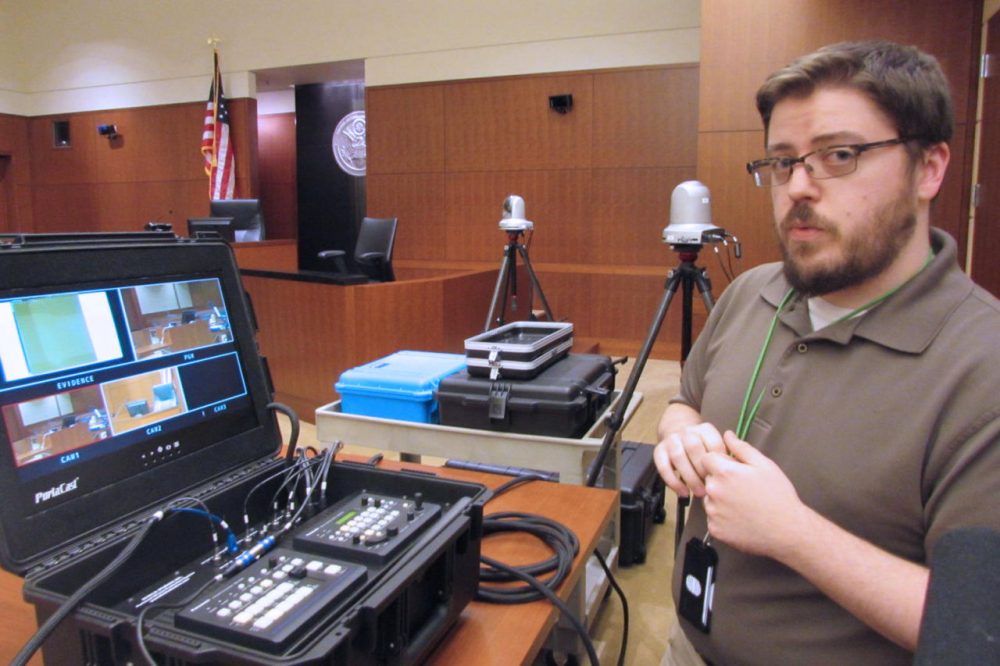 Courtroom technology administrator Jeremy Sites explains the camera setup in U.S. District Court. (Amy Radil/KUOW)