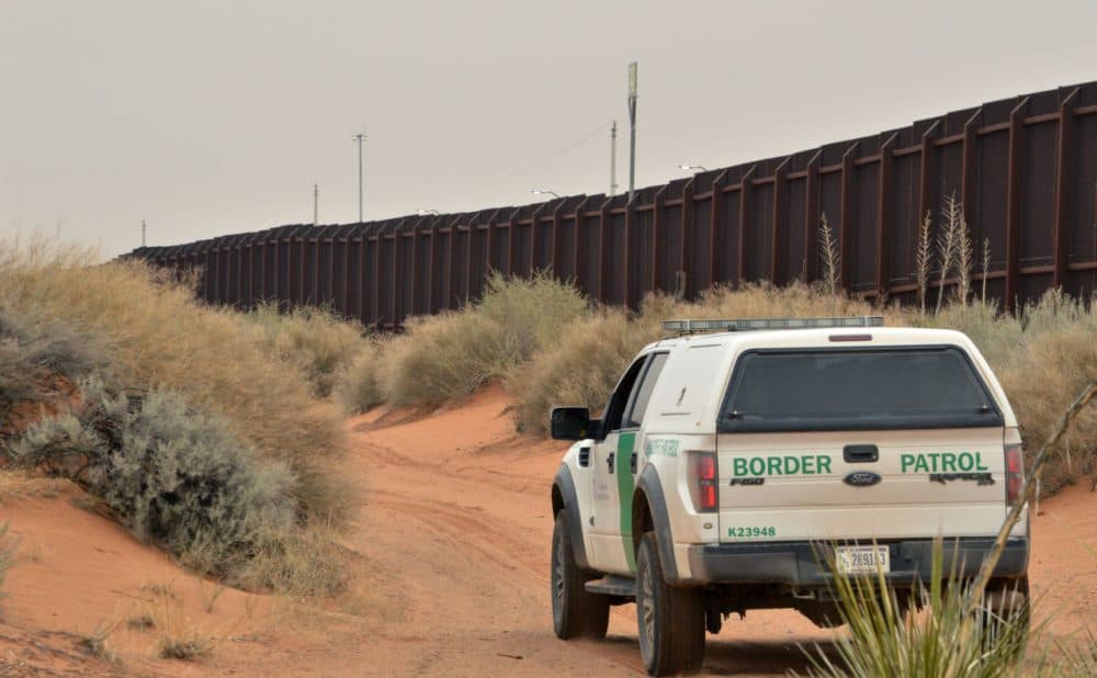A U.S. Border Patrol agent drives near the U.S.-Mexico border fence in Santa Teresa, New Mexico, on Jan. 4.  Secretary of State John Kerry announced Wednesday that the U.S. government will partner with the U.N. to set up processing centers in Latin America where migrants can apply for refugee status before attempting to come to the U.S. (Russell Contreras/AP)