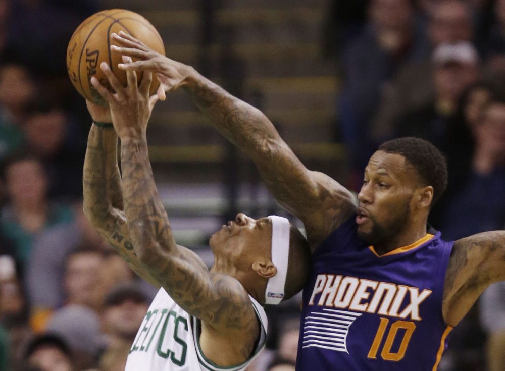 Boston Celtics guard Isaiah Thomas (4) shoots past the attempted block by Phoenix Suns guard Sonny Weems (10) during Friday's game in Boston. (Stephan Savoia/AP)