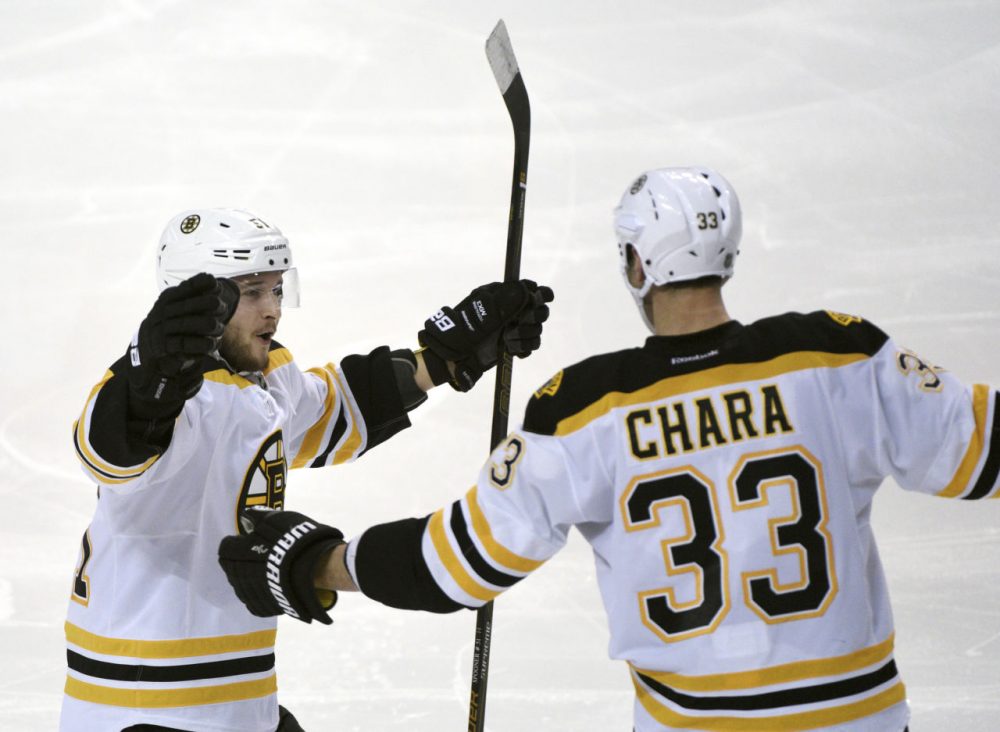 Boston Bruins center Ryan Spooner (51) celebrates with Zdeno Chara (33) after Chara scored during a game against the Buffalo Sabres on Friday. (Gary Wiepert/AP)