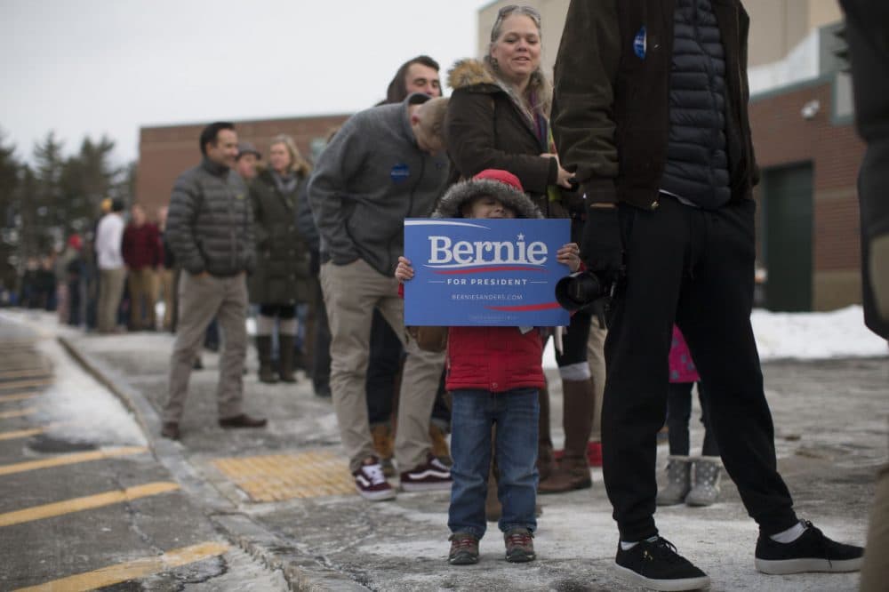 Sam Chausovsky holds a sign as attendees wait in line before a Bernie Sanders campaign event at Bedford High School last week. (John Minchillo/AP)
