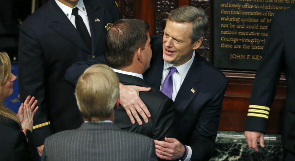 Charlie Baker, right, greets Boston Mayor Marty Walsh as he enters the House Chamber at the State House in Boston on Jan. 8, 2015 for his inauguration as governor of Massachusetts. (Elise Amendola/AP)
