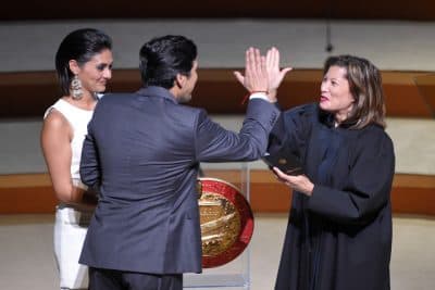 In this file photo, Democratic Sen. Kevin de Leon, center, the 47th President pro Tempore of the California State Senate, high-fives Tani G. Cantil-Sakauye, right, Chief Justice of California after helping to catch the microphone as it was dropped while he was being sworn in as de Leon's daughter LLuvia Carrasco holds the Bible, Wednesday, Oct. 15, 2014, in Los Angeles. (AP Photo/Mark J. Terrill)