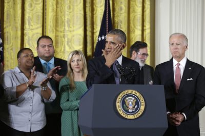 President Barack Obama, joined by Vice President Joe Biden and gun violence victims, wipes a tear from his cheek as speaks in the East Room of the White House in Washington, Tuesday, Jan. 5, 2016, about steps his administration is taking to reduce gun violence. Also on stage are stakeholders, and individuals whose lives have been impacted by the gun violence. (AP Photo/Carolyn Kaster)