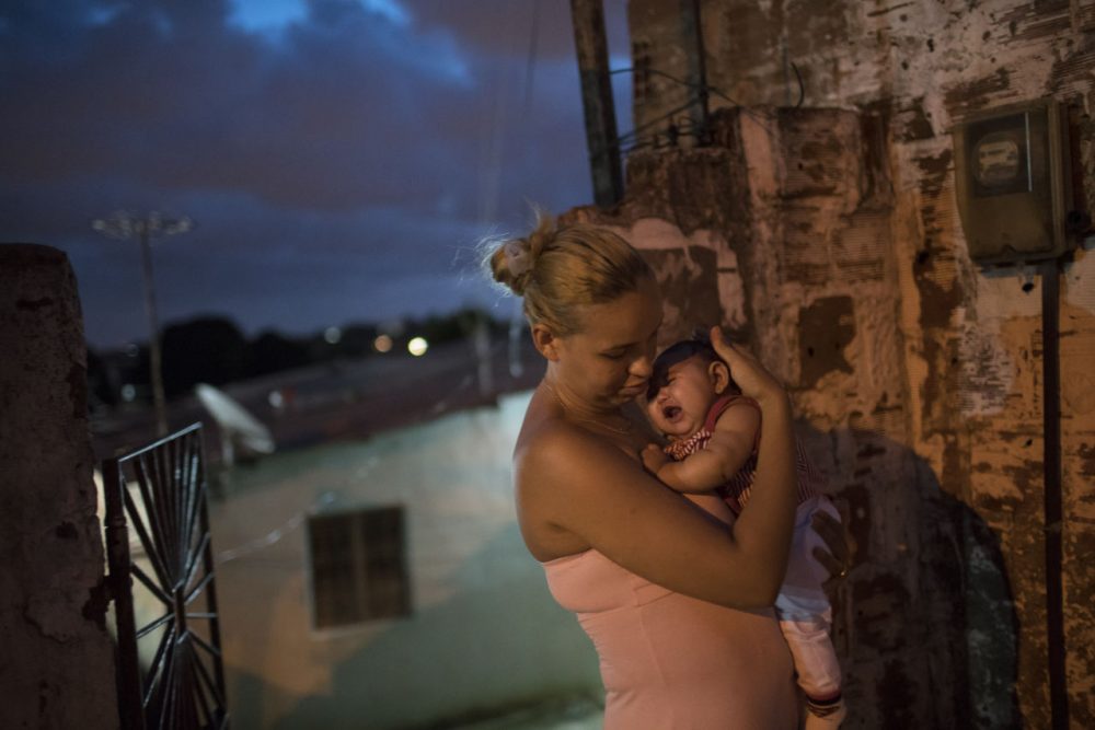 Gleyse Kelly da Silva, 27, holds her daughter Maria Giovanna, who was born with microcephaly, outside their house in Recife, Pernambuco state, Brazil. (Felipe Dana/AP)