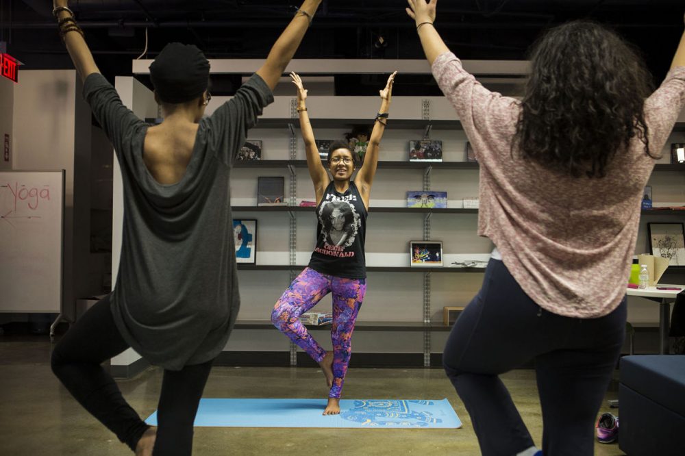 Twenty-four-year-old Chanelle John, center, last spring founded what she says is Boston's first yoga class for people of color. Here, she leads exercises in the South End. (Jesse Costa/WBUR)