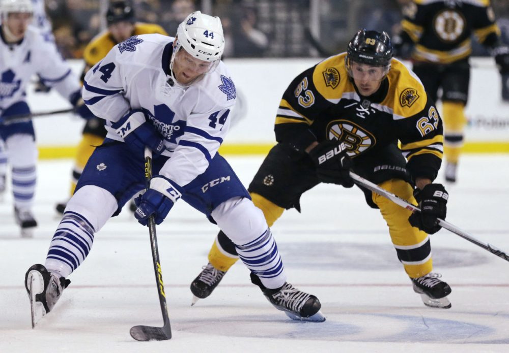 Toronto Maple Leafs defenseman Morgan Rielly handles the puck away from Boston Bruins left wing Brad Marchand during the second period of the game. (Charles Krupa/AP)