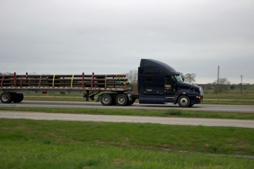 A truck on I-10 in Colorado County, Texas, hauls drilling pipe in 2013, (Dave Fehling/Houston Public Media)