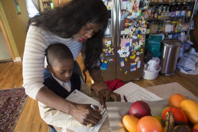 Suzanne Bouffard: &quot;Kindergartners and preschoolers are counting on us to help them do and be their best. Ending suspensions is a vital step, but it’s just the beginning.&quot;
Pictured: Delores Michel helps her son, Dashon, sign his homework assignment. The first grader was one of hundreds of Massachusetts children suspended from kindergarten last year. (Jesse Costa/WBUR)