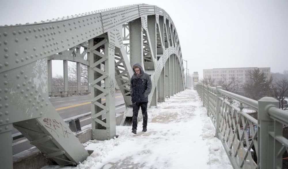 James Bridger, 22, crosses BU Bridge in Boston during Monday's storm. He's visiting Boston from the United Kingdom and when asked about the weather here, said, &quot;I've seen better.&quot; (Robin Lubbock/WBUR)