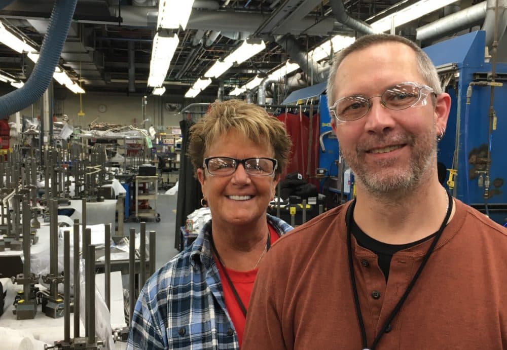 GE employees Debbie Birdsey (left) and Brad Slayton pose for a photo at the Hooksett, N.H., plant. Birdsey is retiring in coming months and has mixed feelings. She said she felt lucky to work where she does. But the factory is struggling to attract young workers. (Jill Ryan/Here &amp; Now)